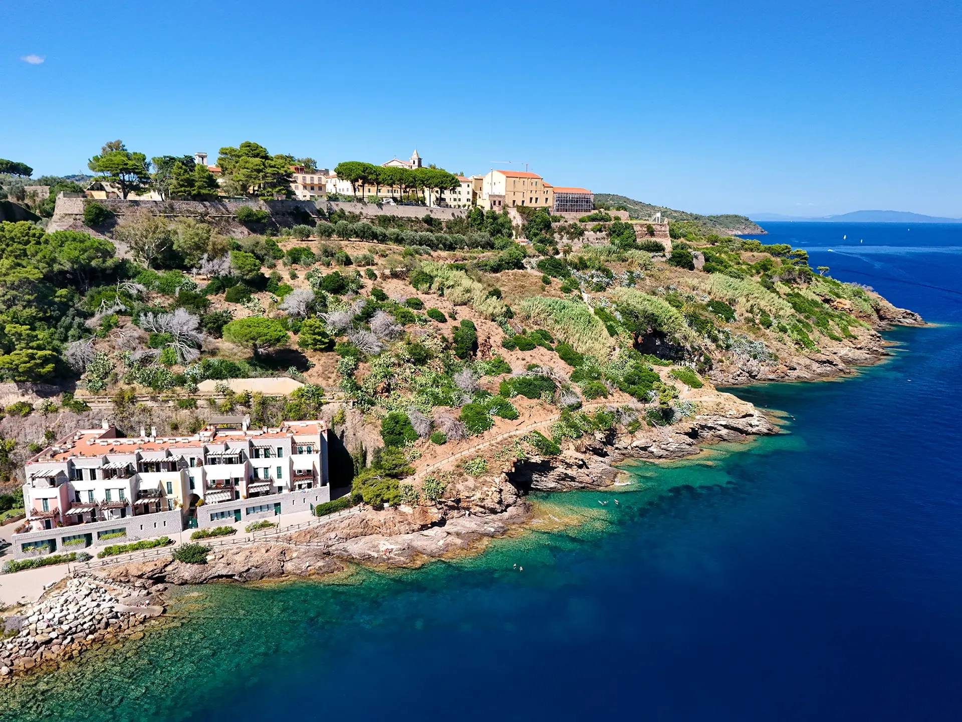 Vista aerea del promontorio dell'Elba con residence sulla scogliera e mare turchese