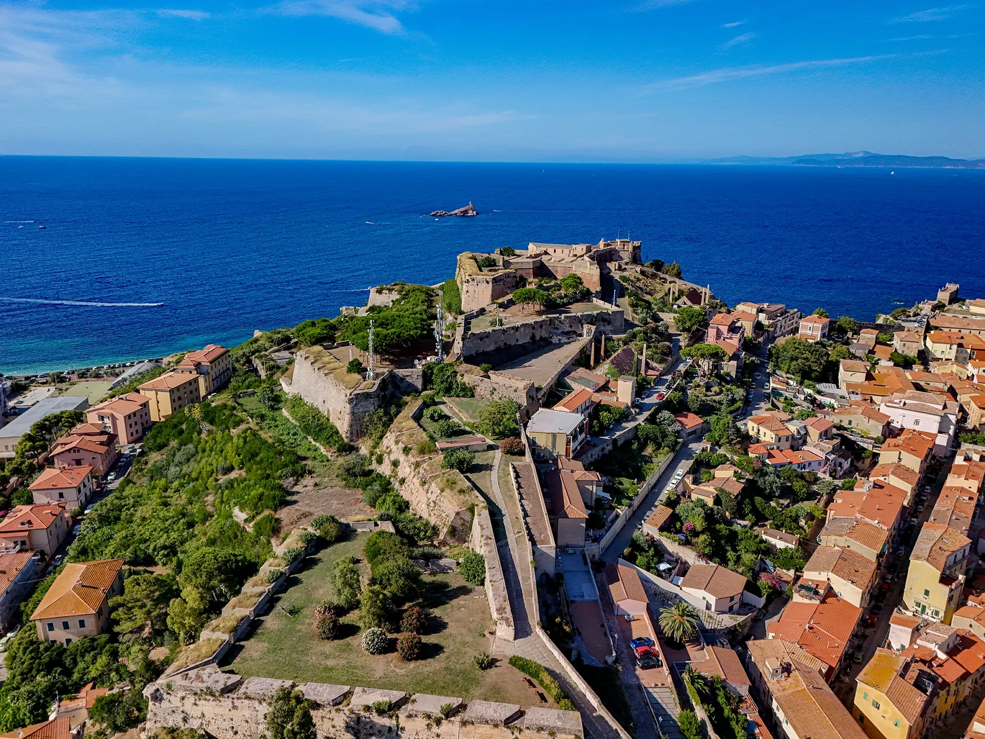 Vista aerea del borgo fortificato di Capoliveri all'Isola d'Elba, circondato dal mare blu intenso