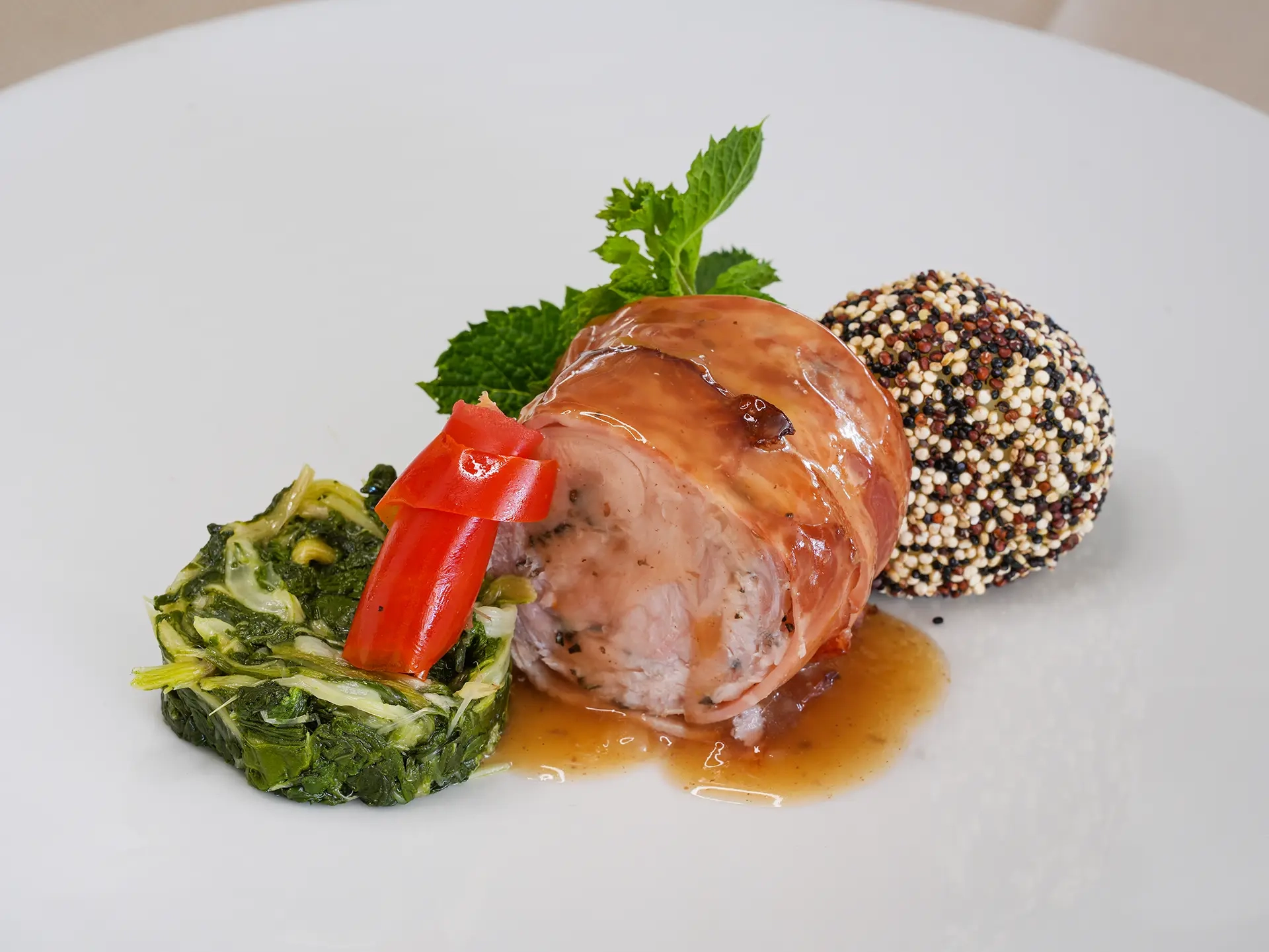 Involtino di carne glassato con verdure saltate, pomodoro e polpetta di quinoa nera