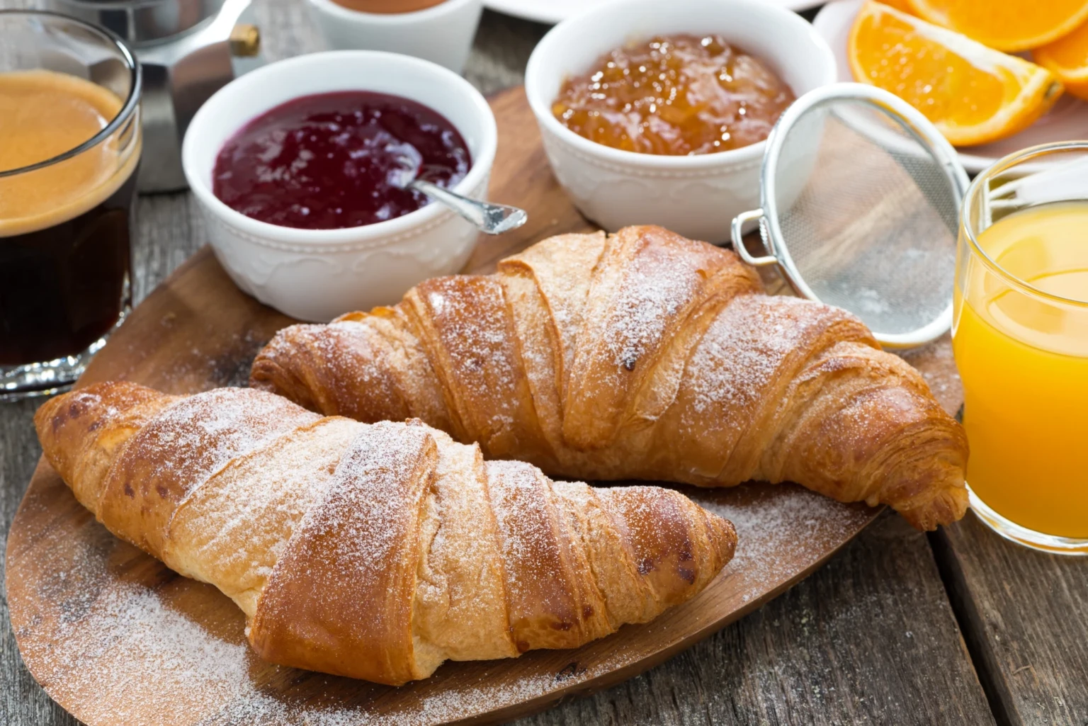 Croissant con marmellate colorate, caffè e succo d'arancia per la colazione in hotel